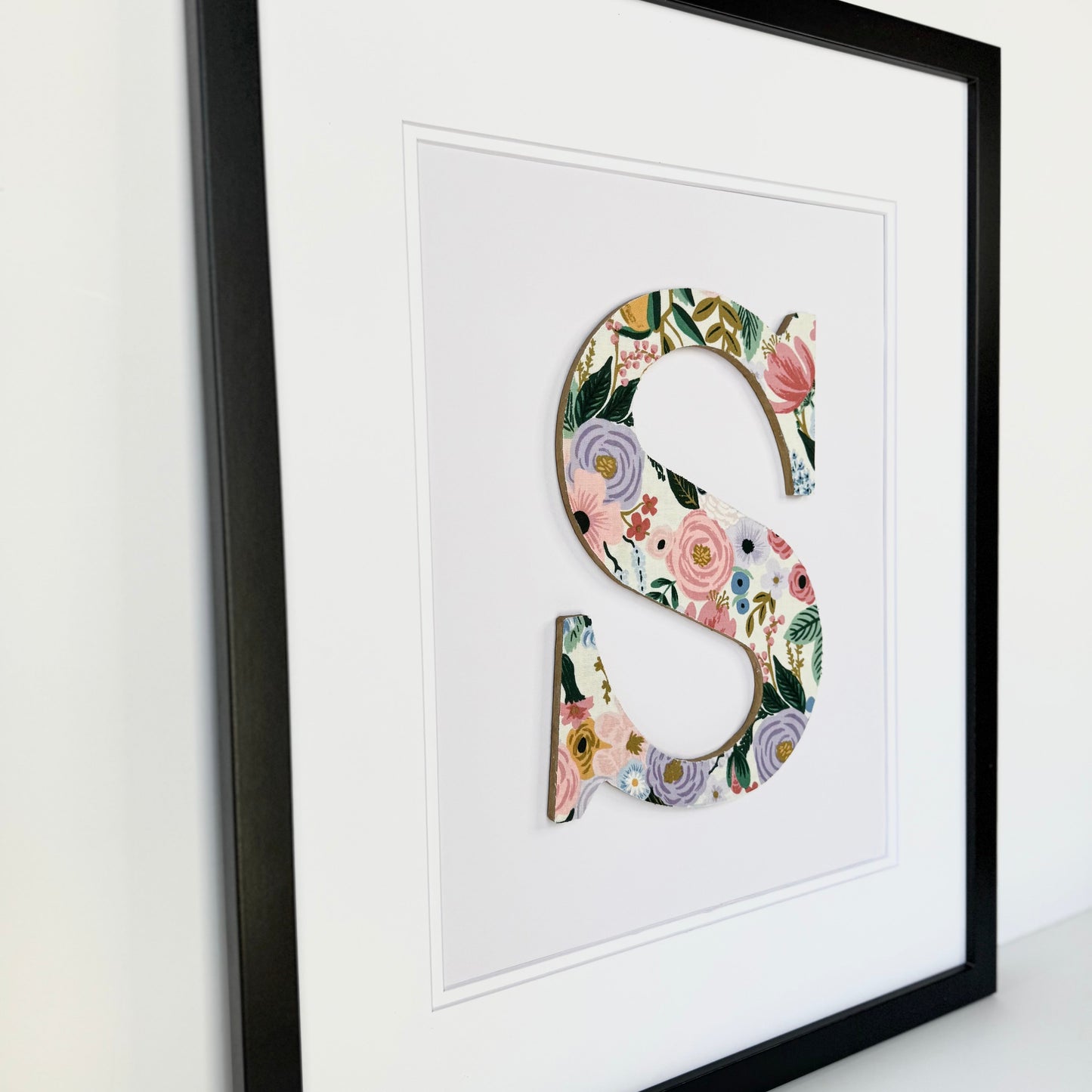 Black Framed letter S with a pink and lavender floral pattern
