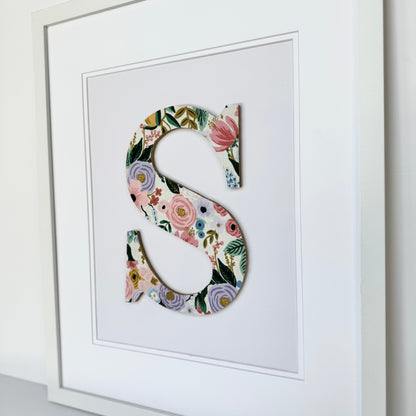 White Framed Nursery letter S with a pink and lavender floral pattern on a pale lavender background